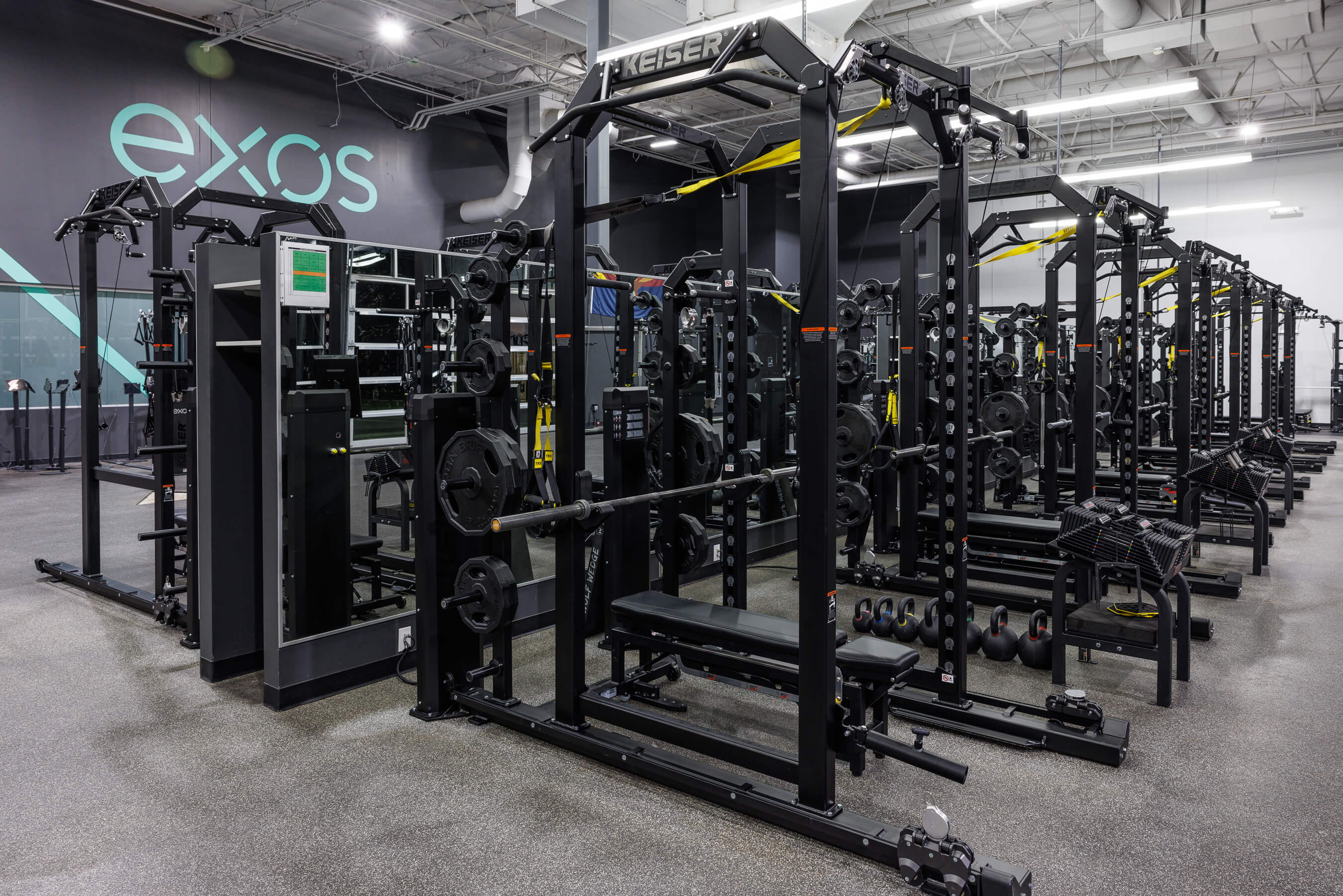 Image of rows of Keiser Power Racks at an Exos facility