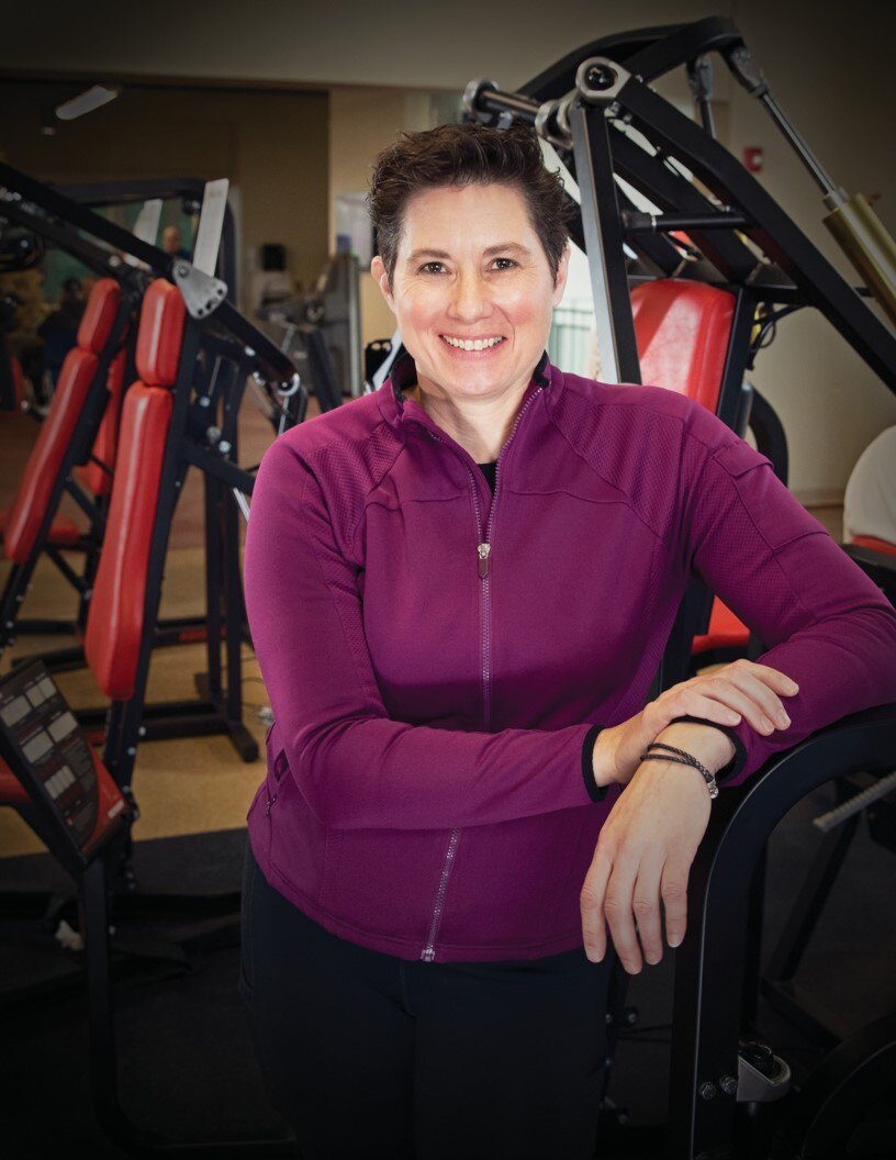 Woman leaning on Keiser fitness equipment