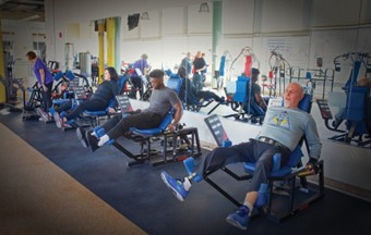 A picture of a diverse group of people of various abilities and ages training on Keiser lower body, pneumatic-based resistance equipment. 