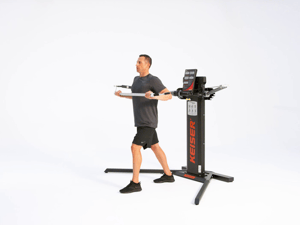 Man performing standing chest press on Keiser Cable Machine