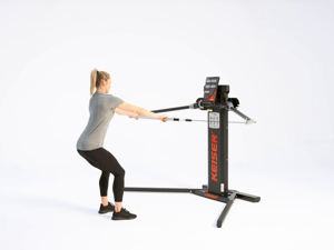 Woman performing standing row on Keiser cable machine