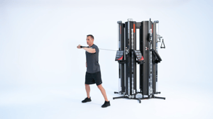 Man performing one arm standing chest press on a Keiser Performance Trainer cable machine