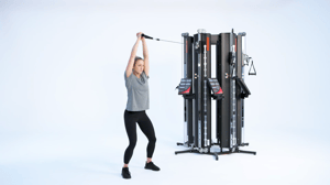 Woman performing a pallof overhead hold on a Keiser performance trainer cable machine