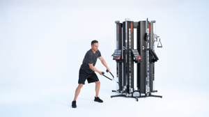Man performing a cable lift on a Keiser Performance Trainer cable machine