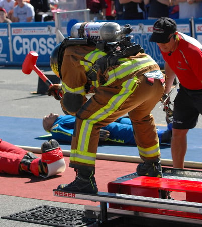 Firefighter competing in a challenge, swinging a sledgehammer on to the Keiser Force Machine