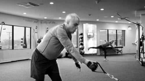 Older adult man doing functional training at a Keiser cable machine