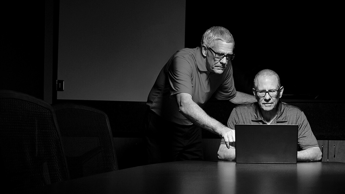 Brothers Dennis Keiser and Randy Keiser looking over a laptop