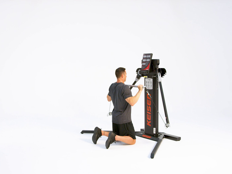 man at cable machine conducting kneeling shoulder press