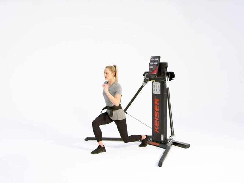 woman at pulley machine conducting scissor jump