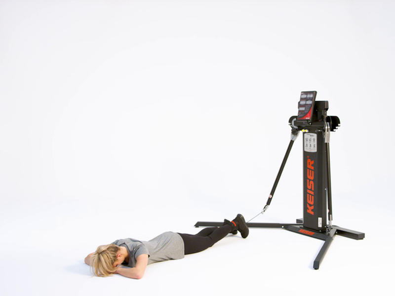 woman conducting Single Leg Prone Leg Curl at cable machine