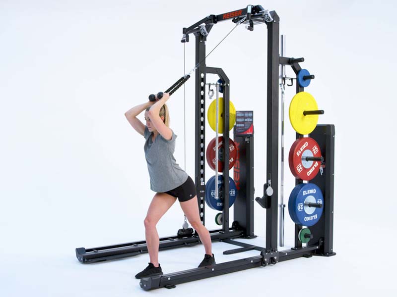 Woman at Rack performing pneumatic resisted Overhead Tricep Extension