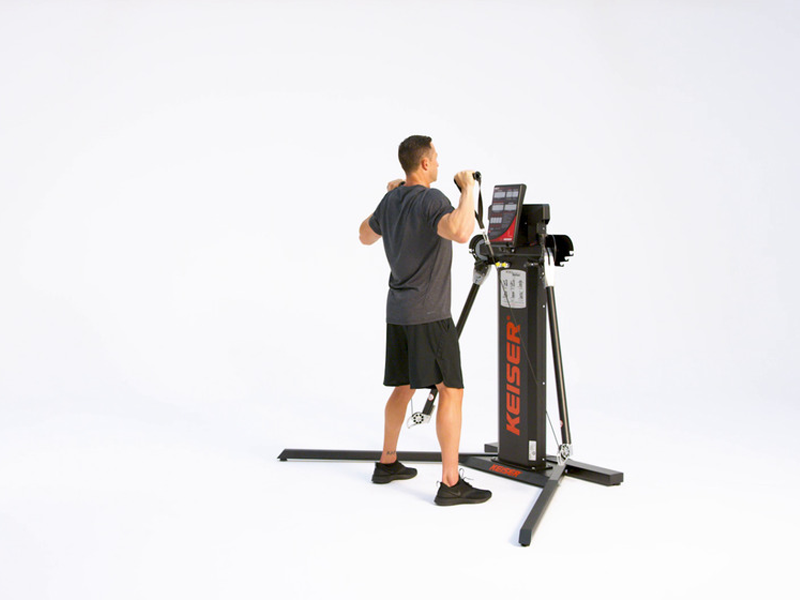 man at cable machine conducting Alt. Standing Shoulder Press