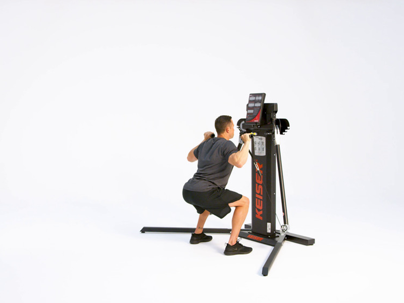 Man on cable machine conducting front squat to press