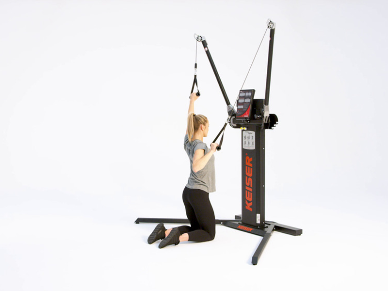 woman at cable machine conducting kneeling alt lat pulldown