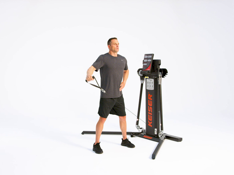 man at Keiser functional trainer performing Standing Side Lateral Raise